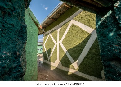 Colorful exterior plaster walls of houses in Harar, Ethiopia with strong sunlight and shadows.