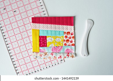 Colorful Fabric Scraps And Quilting Supplies Over White