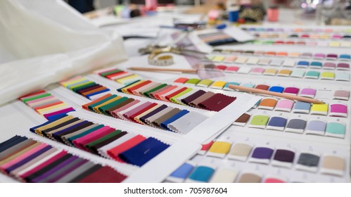 Colorful Fabric and Thread catalog on Seamstress or dressmaker work table background.