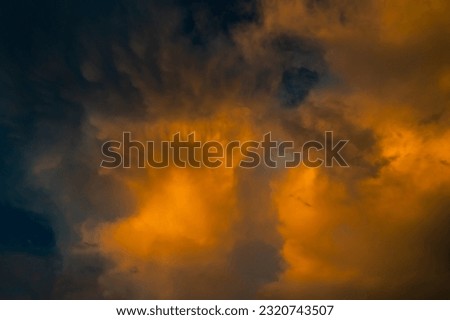 Colorful fantasy sunset clouds sky.Vibrant sunset sky. Warm fire tones. Blue, orange and yellow sunset sky.