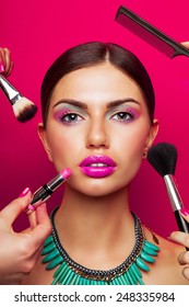 Colorful fashion beauty portrait model and perfect skin  bright make up   big pink  lips   effect necklace  Beautiful young female getting her make  up done against color background 