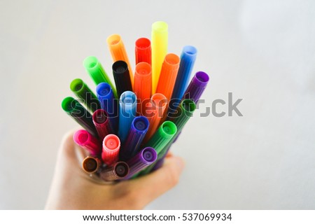 colorful feltpens, pencils in hand