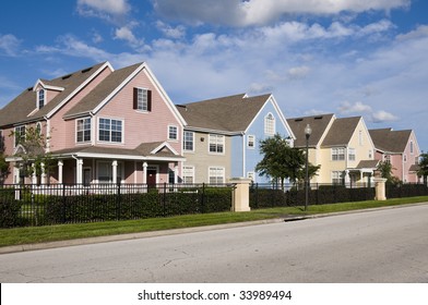 Colorful Fenced In Row Houses With Blue Sky