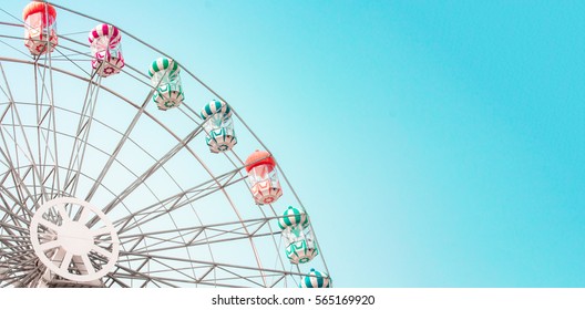 Colorful ferris wheel of the amusement park in the blue sky  background.