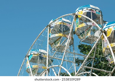 Colorful ferris wheel cabins against a clear sky. - Powered by Shutterstock