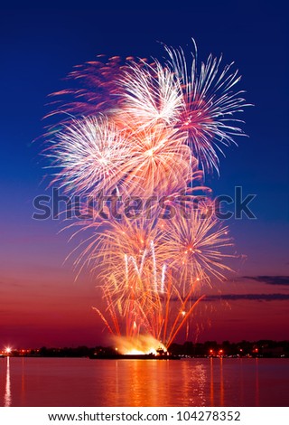 Colorful firework in a night sky, reflection in water