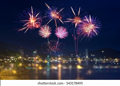 Colorful fireworks display over city on the beach.
Firework celebration sparkling in midnight sky, sea bokeh light at Patong beach, Phuket, Thailand