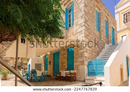 Colorful fishing village of Symi with colorful houses and doors, flower pots on Symi Island in Greece. High quality photo