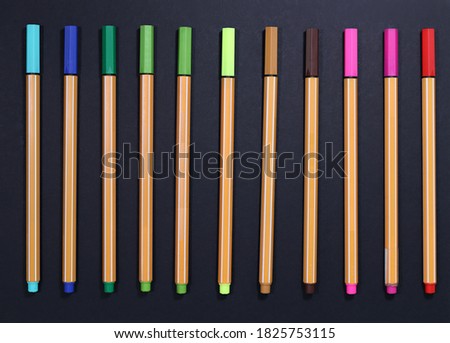 Colorful flatlay fineliner pen with black background