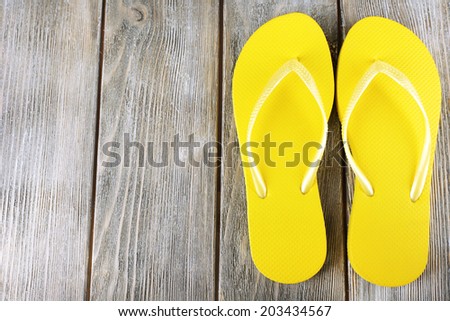 Colorful flip-flops on wooden background