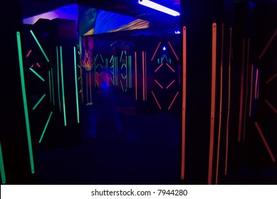 The colorful florescent lights of a laser game room with a blurred laser player.