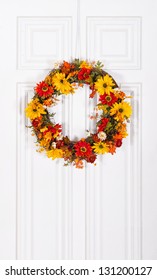 Colorful Flower Wreath Hanging On White Wood Door