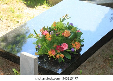 Colorful Flowers On A Black Marble Gravestone