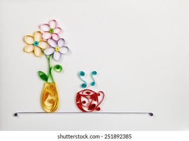 colorful flowers in a vase and a hot cup made of quilling. Location can be used for the text