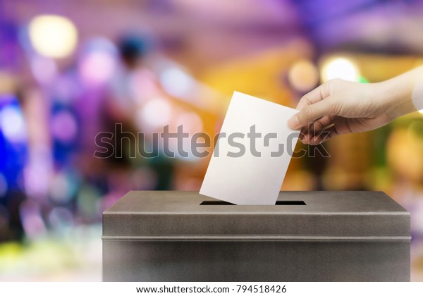 Colorful fo election\
vote, hand holding ballot paper for election vote concept at\
colorful background.