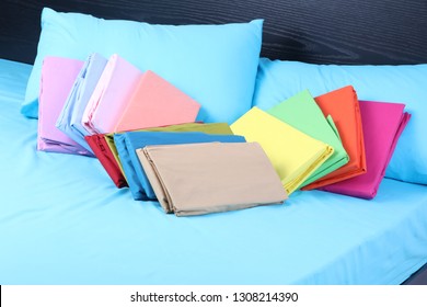 Colorful Folded Duvet On Fitted Sheet Of Bed 