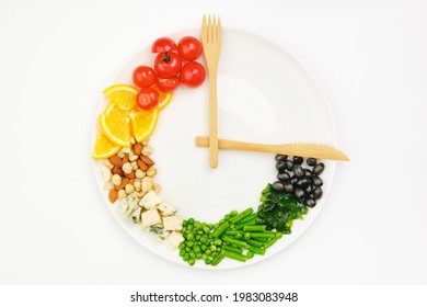 Colorful food and cutlery arranged in the form of a clock on a plate. Intermittent fasting, diet, weight loss, lunch time concept. - Shutterstock ID 1983083948