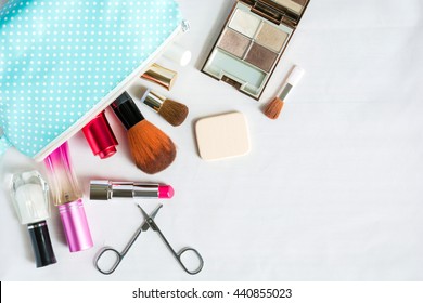 Colorful Frame With Various Makeup Products On White Background With Copy Space, Bag, Lipstick ,powder, Perfume, Scissors, Fingernail Paint, Brush. The Concept Cosmetics Makeup, Beauty, Travel.