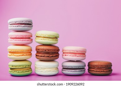 Colorful French macaroni cookies are arranged in a pyramid on the background. Top view, free space