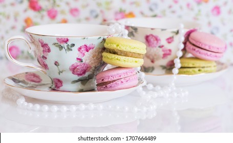 Colorful French Macarons Stacked Next To Floral Fancy Teacup