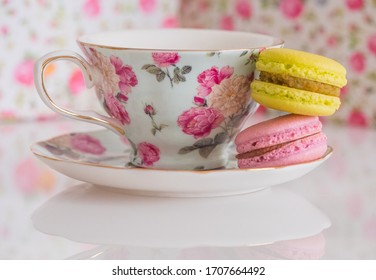 Colorful French Macarons Stacked Next To Floral Fancy Teacup