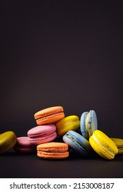 Colorful French Macaroons On A Black. Vertical Background With Copy Space.