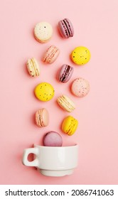 Colorful French Sweet Macarons Fall In White Cup On Pink Background