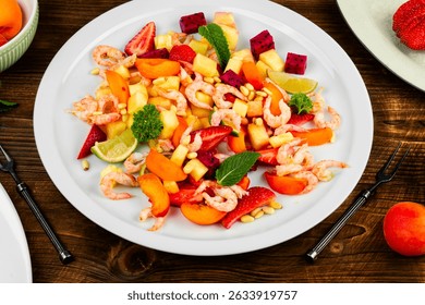 Colorful and fresh seafood salad plate with shrimps, pineapple, apricots, dragon fruit and pine nuts.
