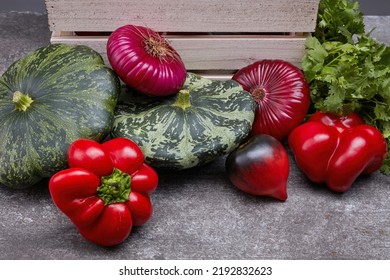 Colorful Fresh Vegetables On A Gray Table And Pine Box. Beautiful Irregular Shaped Vegetables. Food Waste From Supermarket. Trendy Vegetables Concept. Selective Focus