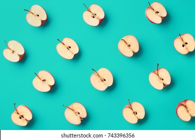 Colorful Fruit Pattern Of Fresh Apple Halves On Blue Background. From Top View