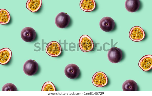 Colorful fruit pattern of fresh passion fruits\
on green pastel background, top\
view