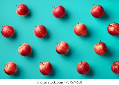 Colorful fruit pattern of fresh red apples on blue background. From top view