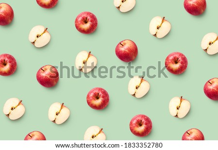Colorful fruit pattern of fresh red apples on light green background