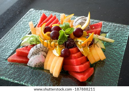 Colorful fruit platter with watermelon, cantaloupe, grapes, oranges, Dragon fruit and mint