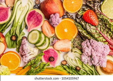 Colorful fruits and vegetables background with half of oranges, and berries , top view. Healthy food and clean eating ingredients concept