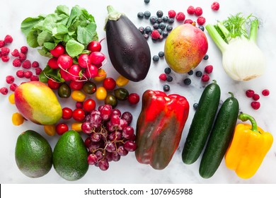 colorful fruits, vegetables and berries scattered on a table of white marble. background eating healthy food