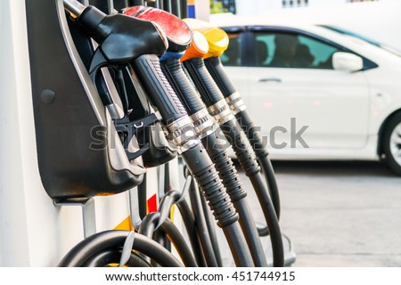Colorful fuel nozzles on the dispenser machine in the petrol station