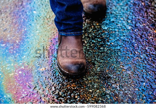 Colorful gas stain on wet
asphalt. This is the type of stain caused by a leak under a car or
truck.
