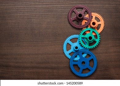 colorful gears on the brown wooden background - Powered by Shutterstock