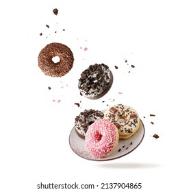 Colorful glazed donuts with mixed sprinkles and crumbs flying isolated on white background. Sweet pastry card. Fresh baked white, brown, pink doughnuts on vintage plate as dessert for coffee break - Powered by Shutterstock