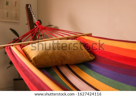 Colorful hammock with soft pillow indoors, closeup