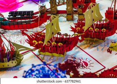 Colorful handicrafts carved paper 3d postcard souvenir. Paper cutting art displayed on a street market in Vietnam.
