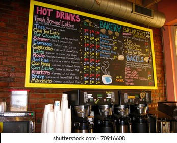 A Colorful Handwritten Menu On A Chalkboard Against A Brick Wall In A Coffee House.