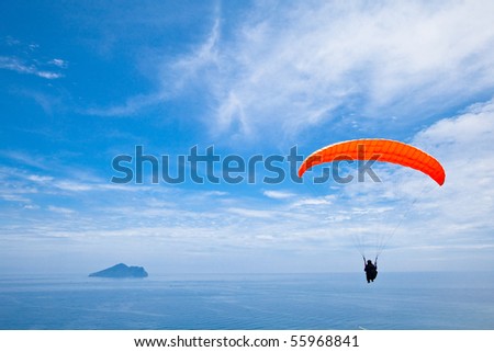 Colorful hang glider in blue sky over  sea