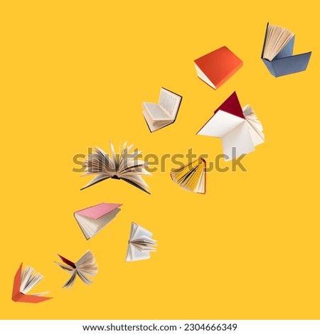 Colorful hardcover books flying isolated on yellow background