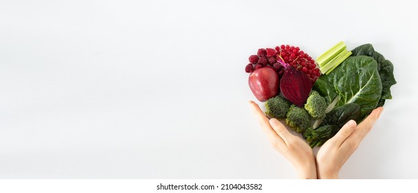 Colorful Heart Shape From Various Fruits And Vegetables With Human Hands Holding It Isolated On White Background. Healthy Plant-based Food Concept. Copy Space For Text. Top View. Love For Fresh Food.