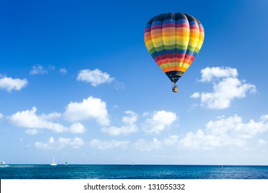 Colorful hot air balloon fly over the blue sea - Shutterstock ID 131055332