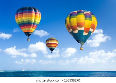 Colorful hot air balloon over the ocean with blue sky background