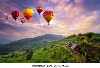 Colorful hot air balloons flying over mountain in sunrise at Khun Pae, Chiang Mai, Thailand.