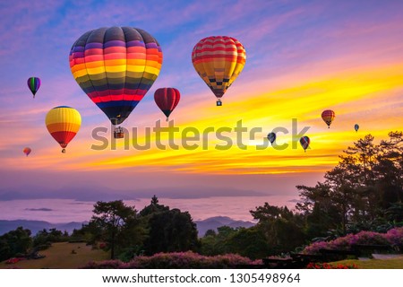 Colorful hot air balloons flying over mountain at Huai Nam Dang National park in sunrise and beautiful sky in morning, Chiang Mai, Thailand.
